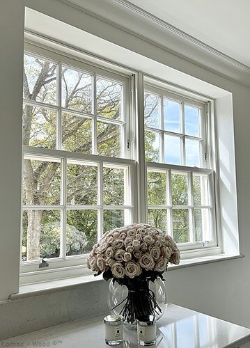 Restored original sash windows in a Georgian London townhouse, with a vase of roses on the windowsill.